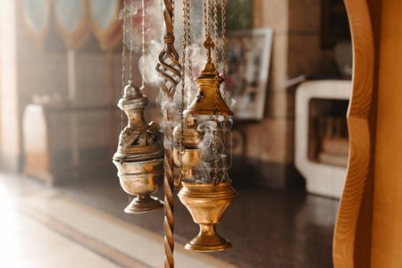 Téléchargez les photos : Un encensoir sur fond de soleil dans une église orthodoxe. Photo de l'attirail de l'église - en image libre de droit