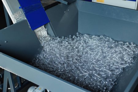 Close-up of PET preforms, the starting point for plastic bottle production on the conveyor.