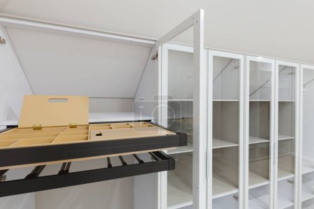 Foto de Un remanso de estilo, con un interior de armario blanco realzado por el encanto moderno de un armario de cristal - Imagen libre de derechos