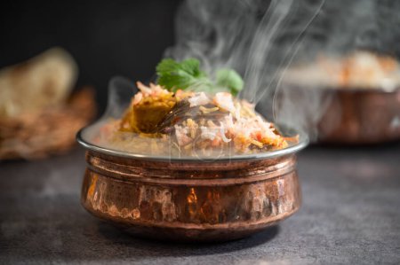 Smoky Spicy Indian biryani pulao in golden bowl with India basmati rice dish with chicken meat curry Ramadan Kareem, Eid. Brass serving bowl with white background, Copyspace.