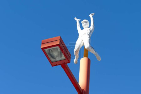 Foto de Fuji-Q Highland, Fujiyoshida City, Prefectura de Yamanashi, Japón - 3 de enero de 2019: Estatua de hombre con las manos en alto en la lámpara en Takabisha - La montaña rusa más empinada. Fondo con hermoso cielo azul. - Imagen libre de derechos
