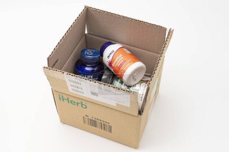 Photo for Fuji, Shizuoka, Japan - March 21, 2023: Cardboard box from iHerb online store with supplements: Tryptophan Plus, Inositol 500 mg and Coconut Oil. Isolated on White Background. - Royalty Free Image