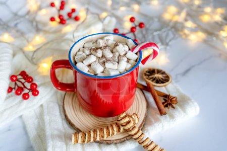 Winter hot drink: red mug with hot chocolate with marshmallow and cocoa. Cozy home atmosphere, festive holiday mood. Rustic style, wooden background