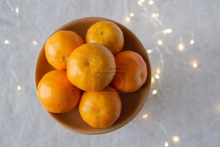 Foto de Placa con mandarinas en el fondo de una guirnalda - Imagen libre de derechos