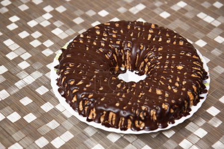 Téléchargez les photos : Chocolate donut on a platter on a golden tablecloth - en image libre de droit