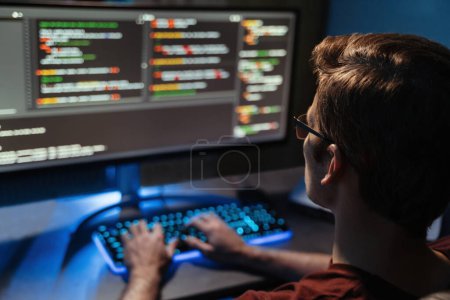 Photo for Back view of man coding for cyber security, programming and working from home late night. Programmer, code and overtime freelancer working at pc screen using php language. Selective focus - Royalty Free Image