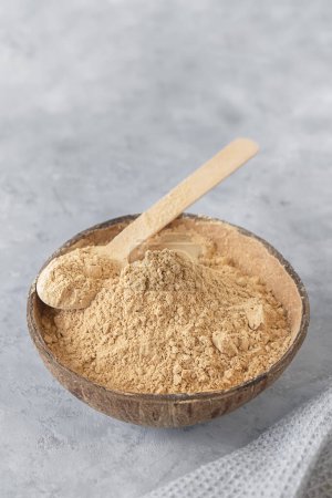 Photo for Bowl of healthy maca root powder on neutral grey background, vertical image with copy space - Royalty Free Image