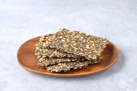 Seed crackers on wooden plate background with copy space