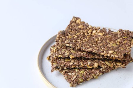 Homemade seed crackers on white background with copy space