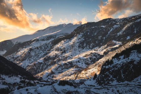 Foto de El Tarter village in a valley between mountains. Sunset light illuminating side of a mountain and clouds. Ski winter holidays, Andorra, Pyrenees - Imagen libre de derechos