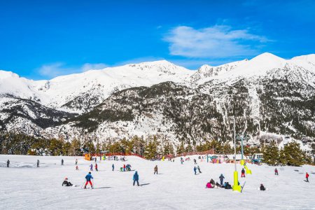 Foto de People, families and kids having fun and learning how to ski and snowboard on El Tarter green slops. Winter ski holidays in Andorra Pyrenees Mountains - Imagen libre de derechos