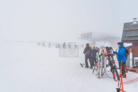 Foto de El Tarter, Andorra, Jan 2020 Skiers and snowboarders exiting ski lift on a top of a mountain, low visibility due to heavy mist, fog or low cloud - Imagen libre de derechos