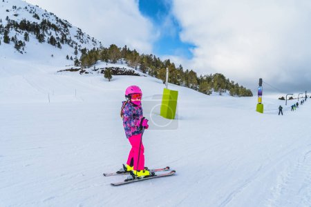 Photo for Young skier, a child, having fun on ski riding towards ski drag lift. Winter holidays in El Tarter, Andorra, Pyrenees Mountains, Grandvalira - Royalty Free Image