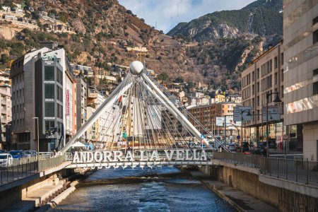 Téléchargez les photos : Andorra la Vella, Jan 2020 Pont de Paris bridge crossing Gran Valira river. Hotels and residential buildings with Pyrenees Mountains in background - en image libre de droit