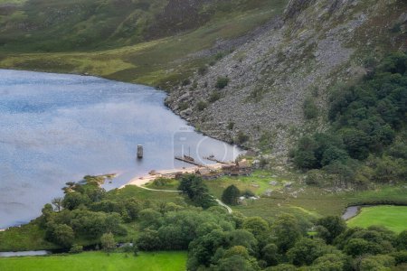 Téléchargez les photos : Longships vikings amarrés sur un quai en bois et village au Lough Tay, appelé lac Guiness dans les montagnes Wicklow, Irlande - en image libre de droit