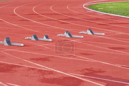 Foto de Pista de carreras de tartán para eventos atléticos con bloques de inicio - Imagen libre de derechos