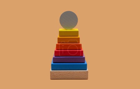 Foto de Pirámide de bloques de madera de colores sobre un fondo marrón. - Imagen libre de derechos