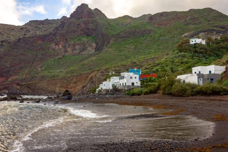 Un vivo contraste de las oscuras arenas volcánicas de Roque Bermejos contra las coloridas fachadas de las casas de pesca, personificando el encanto costero de Tenerife.