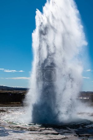 Cette image captivante capture la puissante éruption de Strokkur, l'un des geysers islandais les plus actifs et les plus renommés. Situé dans la zone géothermique au bord de la rivière Hvita, Strokkur est connu pour son