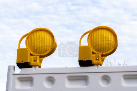 Photo for Two yellow signal flashlight  lamp located on a white plastic panel. Close-up against a cloudy sky. - Royalty Free Image
