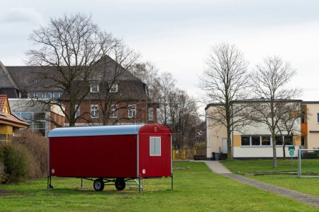 Téléchargez les photos : Une remorque résidentielle mobile debout sur une pelouse au milieu d'un complexe résidentiel. - en image libre de droit