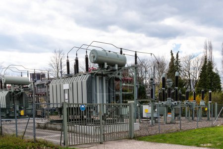 Foto de Un gran transformador eléctrico estacionario contra un cielo nublado. - Imagen libre de derechos