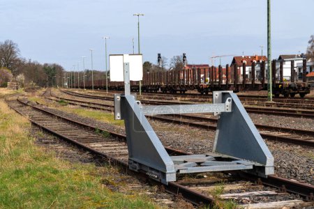 Une impasse sur les anciennes voies ferrées est protégée par une barrière métallique d'avertissement.