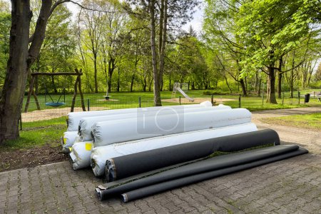 Photo for Rolls of artificial grass wrapped in white plastic film folded near the playground. - Royalty Free Image