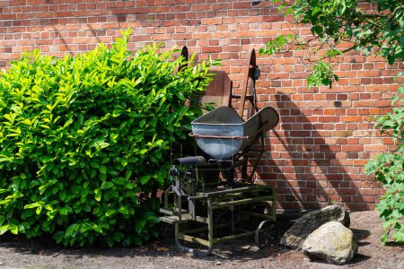 Vieja carretilla robusta y escamas hechas de hierro sólido en un patio de carbón. Se utiliza para retener carbón, briquetas.