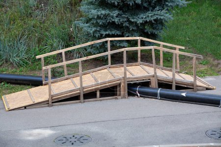 Téléchargez les photos : Temporary wooden bridge over the pipe on construction site. - en image libre de droit