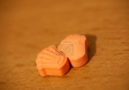 Orange pills with mdma ecstasy dope rolex drug close up background fine art in high quality prints puzzle 632642314