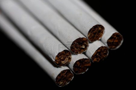 Foto de Una vista de una serie de cigarrillos aislados en el tabaco de fondo negro de cerca dejar de fumar cigarrillo dejar de fumar mal hábito adicto a la nicotina de gran tamaño de alta calidad impresión instantánea - Imagen libre de derechos