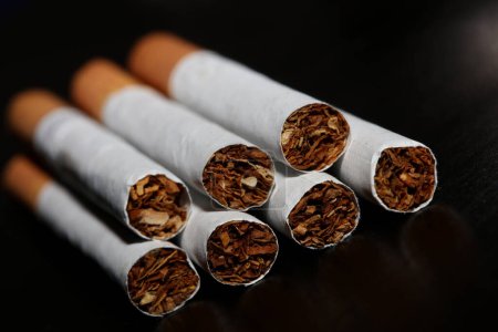 Foto de Una vista de una serie de cigarrillos aislados en el tabaco de fondo negro de cerca dejar de fumar cigarrillo dejar de fumar mal hábito adicto a la nicotina de gran tamaño de alta calidad impresión instantánea - Imagen libre de derechos