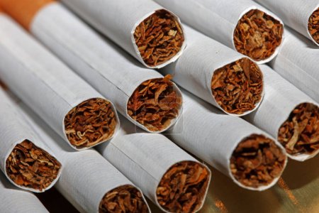 Viele Zigaretten im bunten Hintergrund Nahaufnahme einer Rolle Tabak in Papier mit Filterrohr Nichtraucher-Konzept Bild mehrerer kommerziell hergestellter Zigaretten stapeln Nichtraucher-Kampagne Tabak tötet hohe Neonicotinoide Gefahr