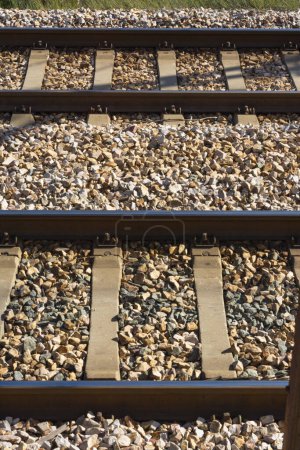 Foto de Las vías del tren y los travesaños entre piedras y grava, desde el lado - Imagen libre de derechos