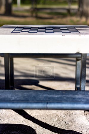 Foto de Mesa de ajedrez de plástico con asiento en un parque público, con enfoque selectivo y espacio para copiar - Imagen libre de derechos