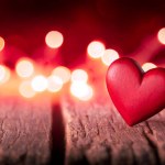 Two Red Hand Carved Wooden Hearts On Rustic Table With Glowing Bokeh Background - Valentines Day 