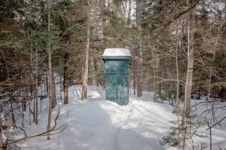Photo for An outside toilet in the wood in winter taken on a sunny winter day in Mont Tremblant, Quebec, Canada - Royalty Free Image