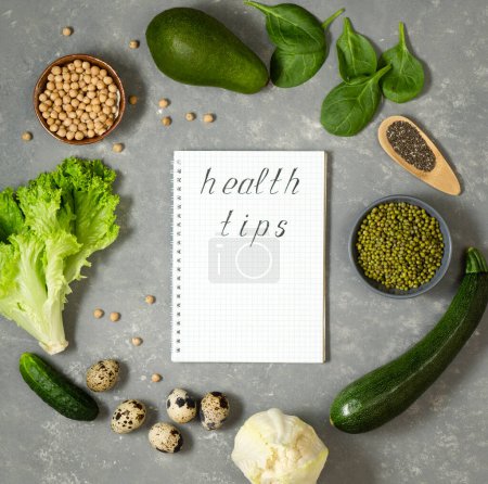 Foto de Plan de dieta con verduras y verduras frescas en un cuaderno de papel sobre una superficie de mesa gris. - Imagen libre de derechos