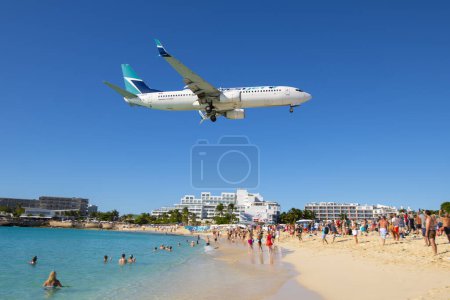 Téléchargez les photos : Westjet Airlines Boeing 737 survolant Maho Beach avant d'atterrir sur l'aéroport international Princess Juliana SXM à Sint Maarten, Pays-Bas Caraïbes. - en image libre de droit