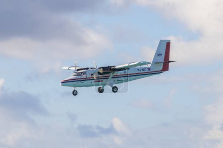 Téléchargez les photos : Winair (Windward Islands Airways) DHC-6 survolant Maho Beach avant d'atterrir sur l'aéroport international Princess Juliana SXM à Sint Maarten, dans les Caraïbes néerlandaises. - en image libre de droit