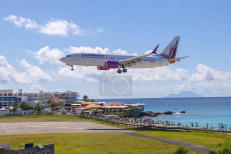 Téléchargez les photos : Caribbean Airlines Boeing 737 survolant Maho Beach avant d'atterrir sur l'aéroport international Princess Juliana SXM à Sint Maarten, aux Pays-Bas Caraïbes. - en image libre de droit