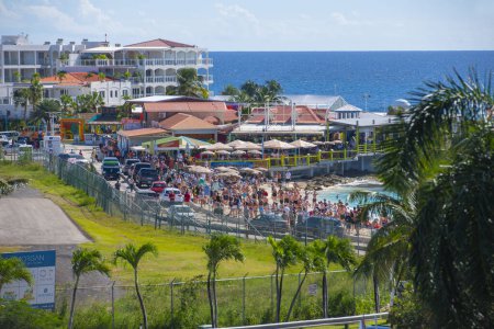 Téléchargez les photos : Maho Beach vue aérienne avec des personnes attendant l'atterrissage de l'avion sur l'aéroport international Princess Juliana SXM à Sint Maarten, Caraïbes néerlandaises. - en image libre de droit
