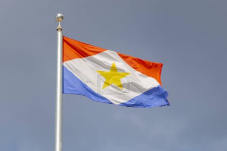 Photo for Flag of Saba flying on a cloudy sky on Saba, Caribbean Netherlands. - Royalty Free Image
