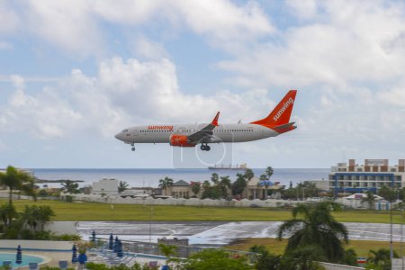 Téléchargez les photos : Sunwing Airlines Boeing 747 Max 8 survolant Maho Beach avant d'atterrir sur l'aéroport international Princess Juliana SXM à Sint Maarten, Pays-Bas Caraïbes. - en image libre de droit