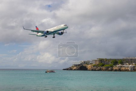 Téléchargez les photos : Delta Air Lines Boeing 757 survolant Maho Beach avant d'atterrir sur l'aéroport international Princess Juliana SXM à Sint Maarten, aux Caraïbes néerlandaises. - en image libre de droit