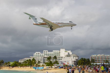 Téléchargez les photos : Le Setai Miami Beach Hawker 4000 survole Maho Beach avant d'atterrir sur l'aéroport international Princess Juliana SXM à Sint Maarten, dans les Caraïbes néerlandaises. - en image libre de droit