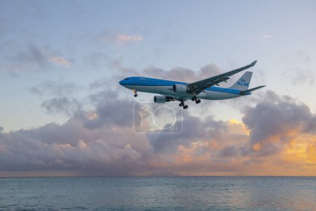 Téléchargez les photos : KLM Airbus 330 survolant Maho Beach avant d'atterrir sur l'aéroport international Princess Juliana SXM au coucher du soleil sur Sint Maarten, Pays-Bas Caraïbes. - en image libre de droit