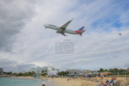 Téléchargez les photos : American Airlines Boeing 737 survolant Maho Beach après le décollage de l'aéroport international Princess Juliana SXM à Sint Maarten, Pays-Bas Caraïbes. - en image libre de droit