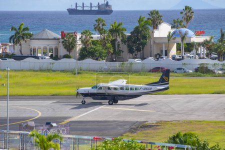 Téléchargez les photos : St. Barth Commuter Cessna 208B Décollage de la Grande Caravane à l'aéroport international Princess Juliana SXM près de Maho Beach à Sint Maarten, dans les Caraïbes néerlandaises. - en image libre de droit